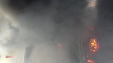 Fabrikanın çatısında tepeden aşağıya doğru yanan yangın. Hava kirliliği.