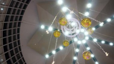 Güzel ışık ve top süslemeleri olan yapay kar evin içinde asılı.