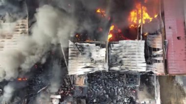 Hava manzaralı itfaiyeci fabrikada yanan ateşe su püskürtüyor.