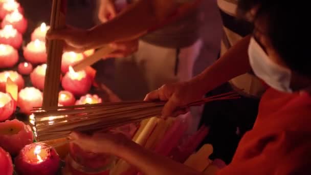 トップビューの選択は 手が中国の寺院でハスのろうそくと線香を燃焼焦点を当て — ストック動画