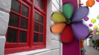 Kırmızı pencerenin yanında dönen fırıldak oyuncağını seç