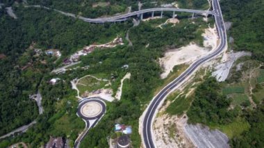 Hava görüntüsü Bukit Kukus tepe bölgesinin yakınına açılmadan önce yolu eşleştirdi