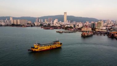 Georgetown, Penang, Malezya - 27 Aralık 2021: Gökyüzü görüntüsü Penang Adası yakınlarındaki sarı terör feribotunu izliyor
