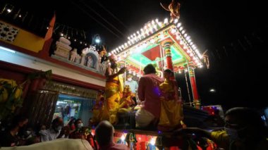 Bukit Mertajam, Penang, Malaysia - Mar 18 2022: Priest carry the offering oil lamp at chariot at Kovil Sungurumbai Nattukkottai Chettiars Sri Thendayuthapani Temple
