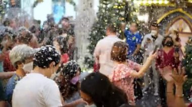 Georgetown, Penang, Malezya - 25 Aralık 2021: Yüz maskeli halk üstten sahte kar yağışının keyfini çıkarın