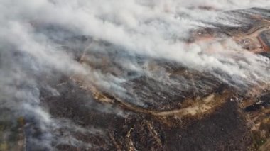 Aerial rotation view fire smoke at the open area of landfill site