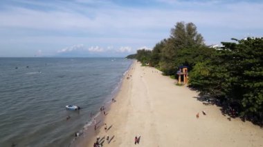 Batu Ferringhi, Penang, Malaysia - Dec 22 2021: Aerial view tourist enjoy the beach activity at stretch of beach at Batu Ferringhi