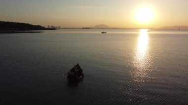Jelutong, Penang, Malaysia - Jan 15 2022: Aerial view local fisherman with row boat at sea in morning sun light