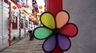Select focus colorful decoration pinwheel at back lane. Motorcyclist move at the back lane