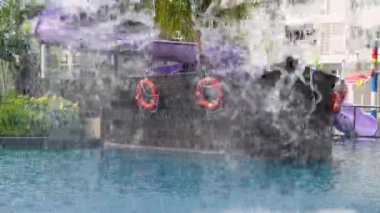 Waterfall at the blue pool. Background is ship shade water park and slide