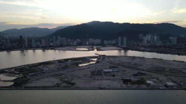 Aerial move toward the reclamation island in sunset hour