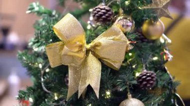 Close up gold ribbon decoration and twinkle led light at Christmas tree