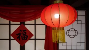 Select focus lighted red chinese lantern and hanging fu on front door during spring festival and lunar new year, The character mean good luck, prosperity and happiness.