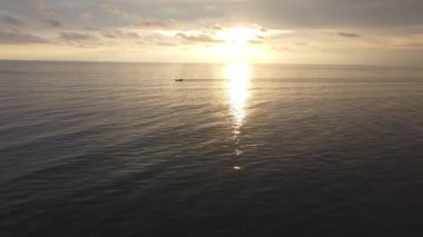 Aerial move toward fishing boat move at sea during sunset hour