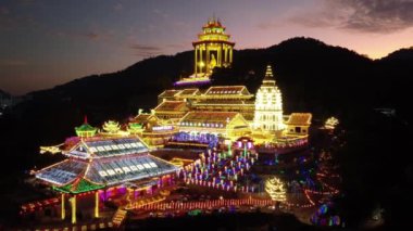 Ayer Itam, Penang, Malaysia - Feb 19 2022: Aerial dramatic push forward Kek Lok Si Temple in night during dramatic sunset hour