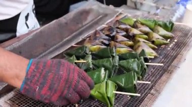 Sata food is cooked on the fire gas. Spiced fish meat wrapped in banana leaves