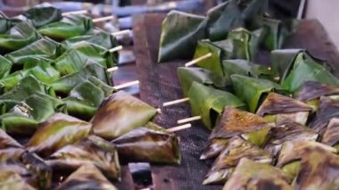 Sata street food is making barbecue of meat wrap in palm leaves. Delicious street food