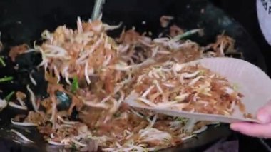 Fried Char Kuey Teow on pan is put into paper plate. Delicious Malaysia street food