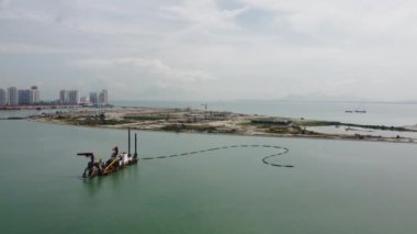 Gurney, Penang, Malaysia - Jun 25 2022: Aerial move toward dredger ship near reclamation land of Tanjung Seri Pinang 2
