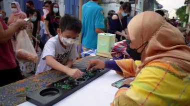 Georgetown, Penang, Malaysia - Jul 07 2022: A kid play congkak game at booth