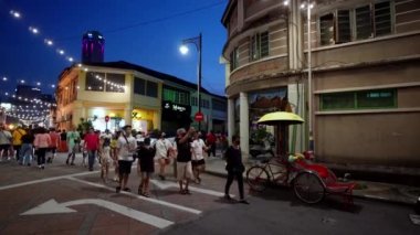 Georgetown, Penang, Malaysia - Jul 07 2022: People wear mask walk at street during blue hour