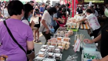 Georgetown, Penang, Malaysia - Jul 30 2022: People wear face mask buy sushi food at stall