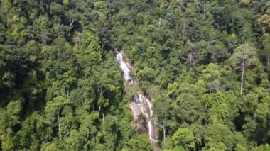 Aerial fly forward Penang Botanical Garden waterfall cascading in sunny day