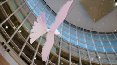 Pigeons statue hanging indoor with fake snow fall down