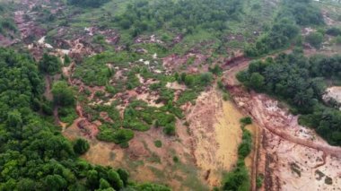 Aerial view red clay soil near the green lush foliage