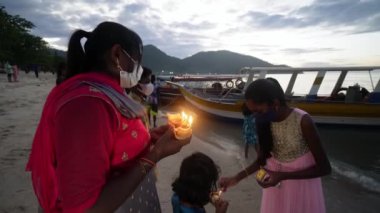 Teluk Bahang, Penang, Malezya - 17 Şubat 2022: Hindu fanatikler plajın yanındaki mumu yaktı