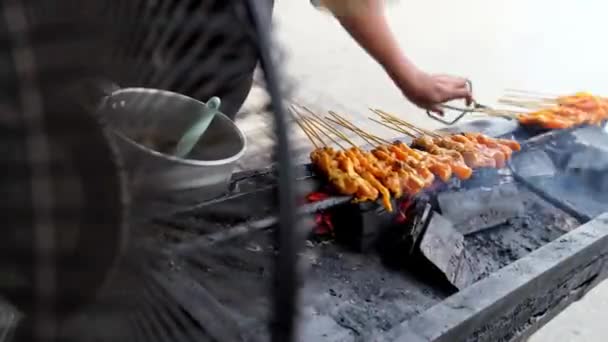Tüccarı Kapatın Rüzgarı Kömüre Üfleyip Tavuk Izgara Satay Yemeği Pişirmek — Stok video