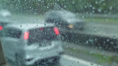 Trafik sıkışıklığı otobanındaki otobüs hareket pencerelerindeki damlacıklara odaklan