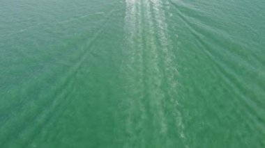 Deniz motorlu teknesini hareket ettirerek dalganın izlerine hava görüntüsü