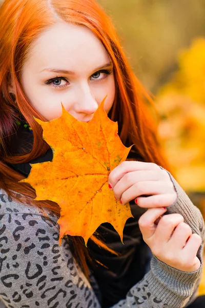 Red-haired girl and maple leaf — Stock Photo, Image