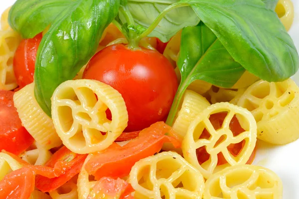 Wheels of pasta with fresh tomatoes — Stock Photo, Image