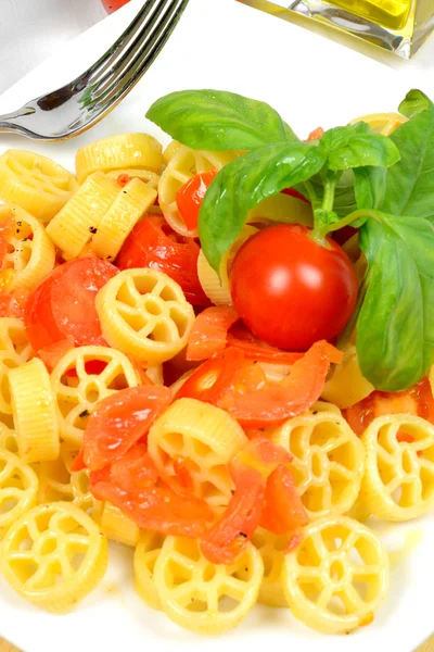 Wheels of pasta with fresh tomatoes — Stock Photo, Image