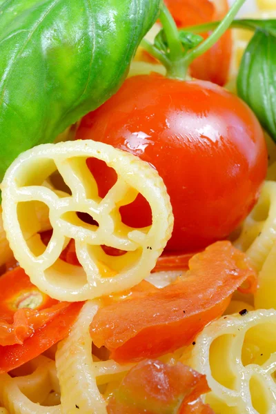 Wheels of pasta with fresh tomatoes — Stock Photo, Image
