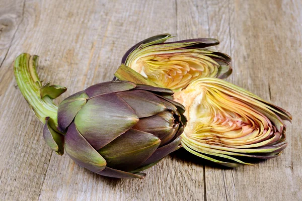 Artichokes on wooden table — Stock Photo, Image