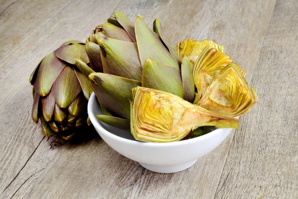 Artichokes on wooden table — Stock Photo, Image