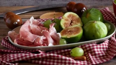 Bir tabak incir ve çiğ jambon üzerinde iz süren çekim. Tipik bir İtalyan aperatifi.