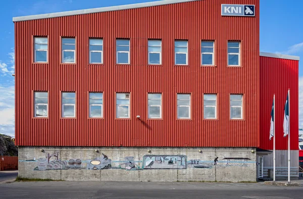 Wall mural painted on building wall depicting inuits tradtional processing of whale meat and blubber in Sisimiut, Greenland on 16 July 2022