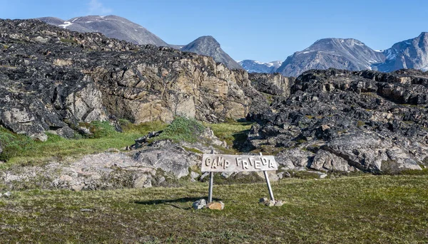 Montainous wilderness landscape with wooden Camp Frieda sign on the Disko Bay coast, Greenland on 18 July 2022