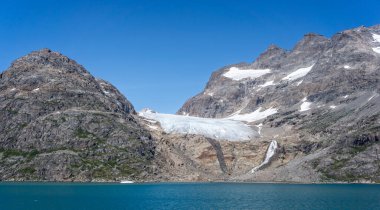 Panorama of mountainous glaciers and meltwater waterfalls in Prince Christian Sound, South Greenland