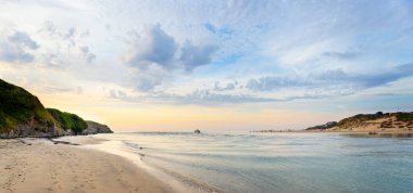 Panoramic sunset seascape  with paddle boarders and motor boat near St Ives,  Cornwall, UK on 13 August 2022