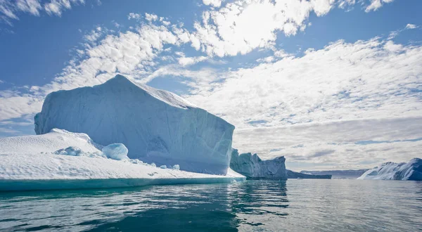 Massive icebergs and dramatic sky in Disko Bay in Greenland