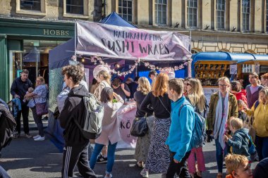 24 Eylül 2022 'de Milsom Caddesi, Bath, Avon, İngiltere' deki Büyük Hamam Festivali 'nde renkli pembe suşi ambarı tabelası.