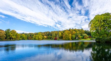 Stourhead, Wiltshire, İngiltere 'de 15 Ekim 2022' de altın sonbahar renklerinde çok renkli ağaçlar ve çalılar manzarası