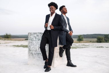 İki modaya uygun Afrikalı siyah erkek, açık havada, şık klasik kıyafetler içinde, şık saç stili, yakışıklı erkekler, manken portresi, moda konsepti, erkek giyimi