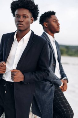 İki modaya uygun Afrikalı siyah erkek, açık havada, şık klasik kıyafetler içinde, şık saç stili, yakışıklı erkekler, manken portresi, moda konsepti, erkek giyimi