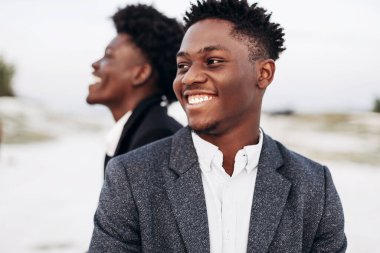 İki modaya uygun Afrikalı siyah erkek, açık havada, şık klasik kıyafetler içinde, şık saç stili, yakışıklı erkekler, manken portresi, moda konsepti, erkek giyimi